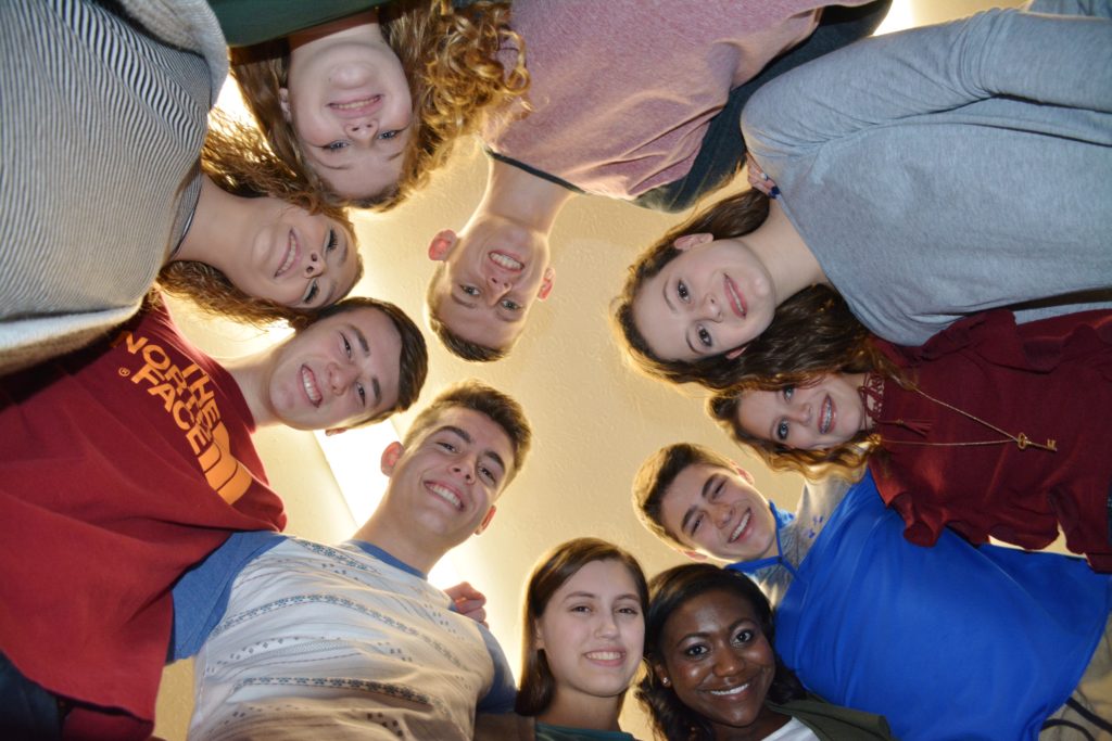 Students in a Circle Looking Down at Camera