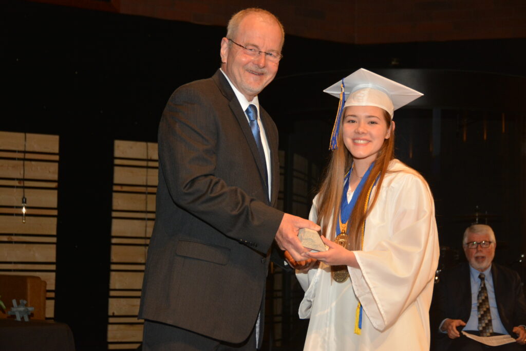 Lake Center Campus Pastor Mr. Jeff Knori presents graduate Jayne Barber with the Living Stone Award for her Christian service and leadership.