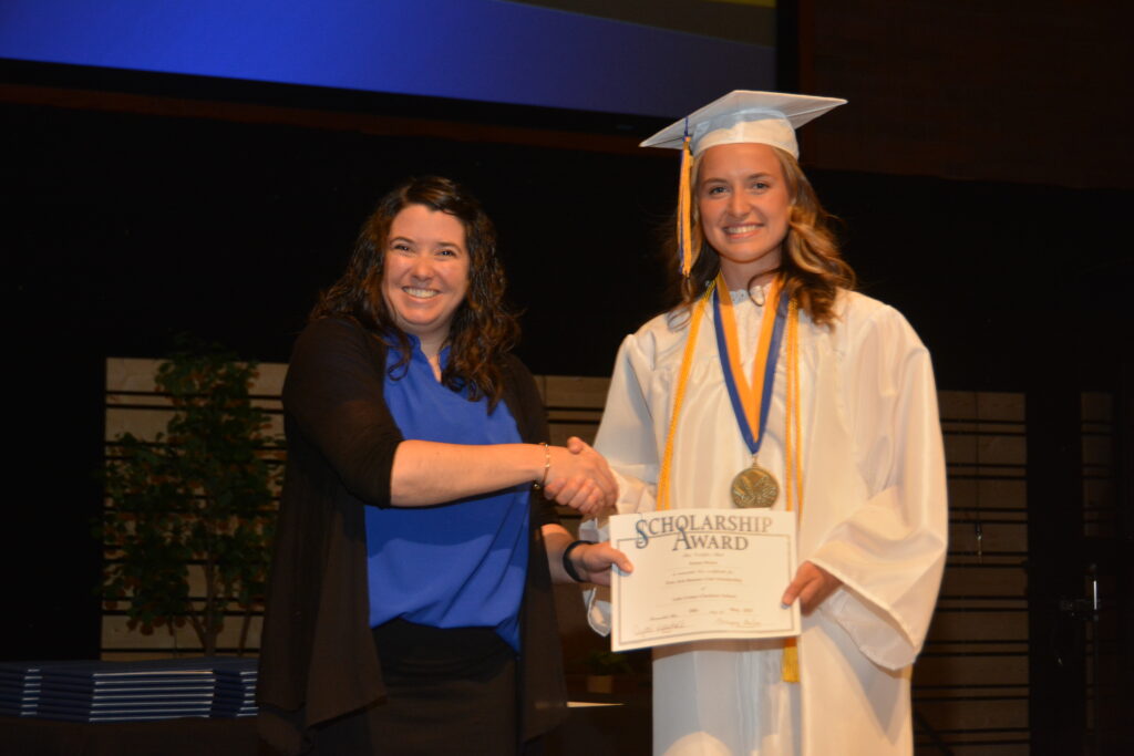 Lake Center Secondary Principal Mrs. Crystal Maarschalk presents the Lake Center Fine Arts Booster Scholarship to Emma Weise